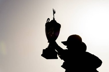 Yarışı kazananların siluetleri zafer şeridinde zafer kazanmış, konfeti yağarken ganimetler yükselmiş, yorucu bir motor sporu savaşının ardından heyecanı ve zaferi yakalamışlar..