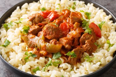 Porkolt, kemiksiz et, kırmızı biber ve masada Nokedli yumurtalı erişteyle servis edilen sebzeli bir Macar güvecidir. Yatay