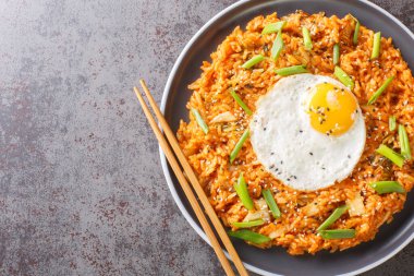 Kimchi pilavı ve üstünde kızarmış yumurta ve masada yakın plan Kore yemeği yemek için çubuklar. Yukarıdan yatay üst görünüm