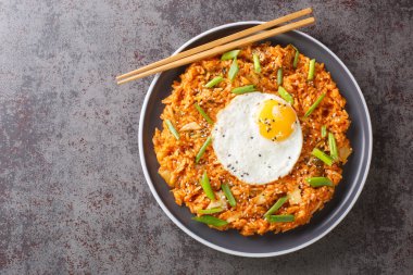 Kore kimchi pilavı, yumurta, yeşil soğan ve masanın üstünde susamlı yakın çekim. Yukarıdan yatay üst görünüm