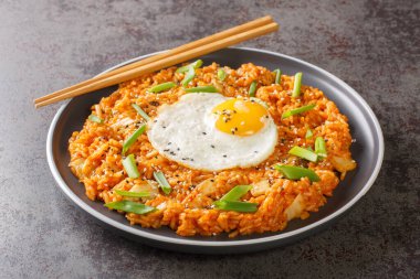 Kore kimchi pilavı, yumurta, yeşil soğan ve masanın üstünde susamlı yakın çekim. Yatay