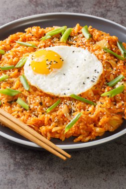 Kimçi usulü kızarmış pirinç Bokkeumbap masanın üzerindeki tabakta yakın plan Kore yemeğidir. Dikey