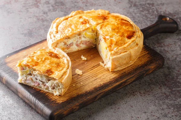 stock image Homemade sliced pie with eggs and bacon close-up on a wooden board on the table. Horizonta