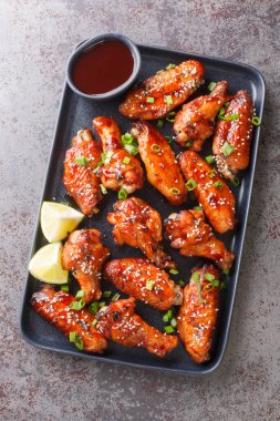 Fast food kızarmış Sticky Hoisin Wings masadaki tabağa yakın çekim yapıyor. Yukarıdan dikey üst görünüm