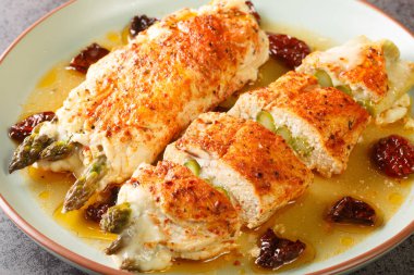 Taze kuşkonmazla doldurulmuş tavuk eti, mozzarella peyniri ve masada kokulu sosla servis edilen güneşte kurutulmuş domatesler. Yatay