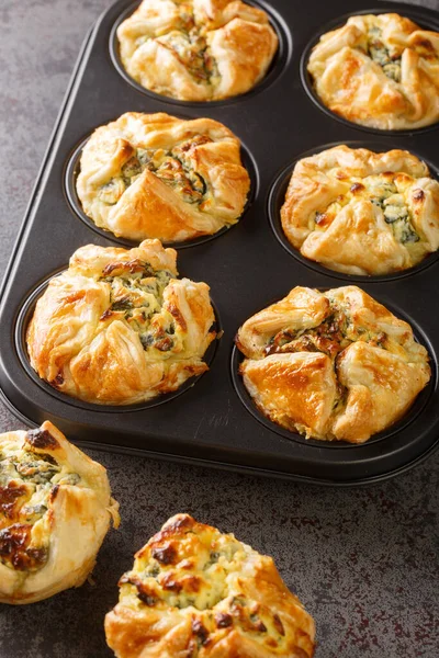 stock image Spinach and feta muffins in puff pastry closeup in the maffin baking form on the table. Vertica