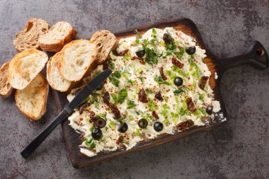 İştah açıcı tereyağı tahtası, aromalı, yemek trendi, yayılmış, abur cubur karanlık arka planda yakın ekmekle servis ediliyor. Yukarıdan yatay üst görünüm