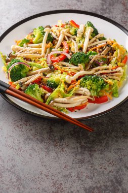 Kızarmış sebze, havuç, biber, lahana, brokoli ve Shimeji kayın mantarlarını masanın üzerinde yakın plan çekimde karıştır. Dikey