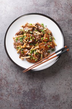 Kayın mantarlı biftek ve teriyaki sosu yeşil soğan ve susam tohumları serpiştirilmiş. Yukarıdan dikey üst görünüm