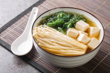 Enoki mantarlı zengin miso çorbası, wakame deniz yosunu ve tofu, vejetaryen, masada yakın plan Asya yemeği. Yatay