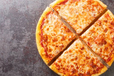 Eritilmiş peynirli ve taban domates soslu lezzetli çıtır New York usulü pizza masanın üzerinde tahtaya yakın plan. Yukarıdan yatay üst görünüm