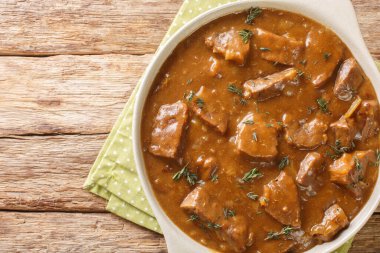 Carbonnade Flamande klasik Belçika yemeği bu güveç ahşap masadaki tencerede bira katılmış et ve soğan içerir. Yukarıdan yatay üst görünüm