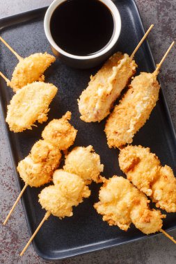 Kushikatsu, Osaka 'da özel bir yemektir. Masanın üzerindeki tabakta bol yağda kızartılmış sebze, et ve yumurtadan oluşur. Yukarıdan dikey üst görünüm