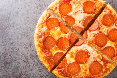 Masadaki tahta tahtaya yakın plan sosisli ve peynirli nefis dilimlenmiş pepperoni pizza. Yukarıdan yatay üst görünüm