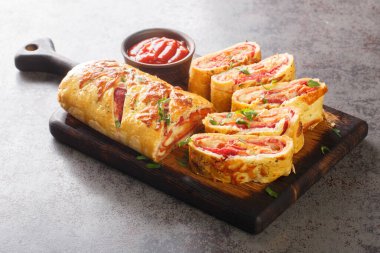 Hot Italian stromboli roll stuffed with salami sausage and mozzarella cheese close-up on a wooden board on the table. horizonta clipart