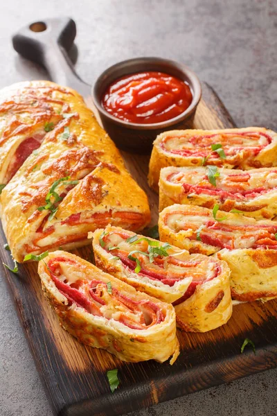Homemade Stromboli pizza with cheese, pepperoni, salami closeup on the wooden board on the table. Vertica