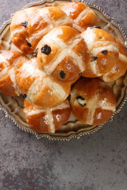 Homemade Hot Cross Buns Ready for Easter closeup on the plate on the table. Vertical top view from abov