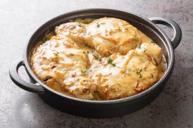 Fried spicy pork chops and then braised in creamy onion gravy closeup on the pan on the table. Horizonta