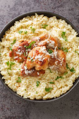 Chicken with Garlic Parmesan Rice closeup on the plate on the table. Vertical top view from abov