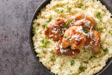 Arborio rice with parmesan and garlic served with fried chicken close-up in a plate on the table. Horizontal top view from abov