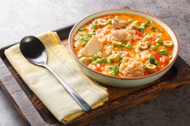 Asopao de pollo, sofrito, pilav, domates ezmesi ve masadaki kaseye yakın duran tavuk parçalarından oluşan bir Karayip tabağıdır. Yatay