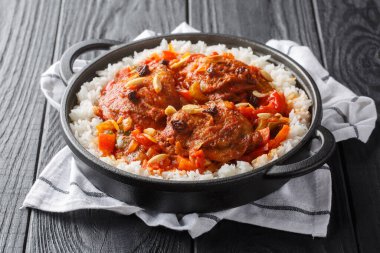 Taşralı Kaptan Tavuk süper lezzetli körili domates sosunda pişiriliyor ve masanın üzerindeki tavada yakın plan beyaz pirinçle servis ediliyor. Yatay