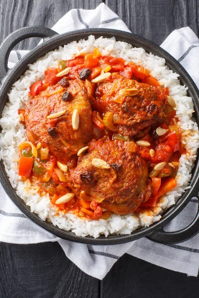Country captain is a curried chicken and rice dish, which is popular in the Southern United States closeup on the pan on the table. Vertical top view from abov