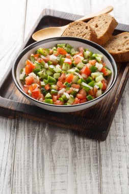 Pipirrana tipik Malaga İspanyol salatası soğan, domates, yeşil biber ve salatalık tabağın üzerine yakın plan. Dikey