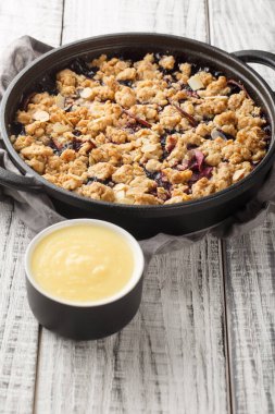 İsveç turtası Smulpaj elmalı ve yaban mersinli yakın plan bir tavada masanın üzerinde. Dikey