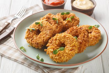 Kızarmış kızarmış kızarmış tavuklu çörekler masanın üzerindeki tabakta yakın plan. Yatay