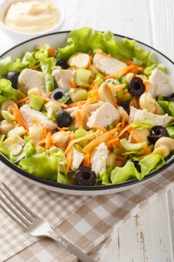 Mantarlı tavuk salatası, havuç, kereviz, zeytin, peynir ve marul, ahşap bir masada yakın plan. Dikey