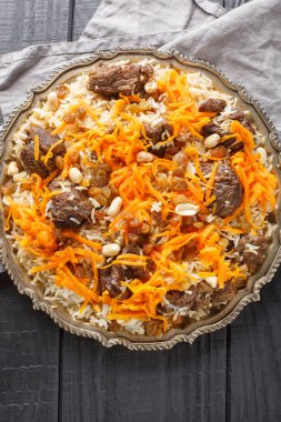 Geleneksel Kabuli Pulao ve tatlı havuç tabakta yakın plan üzümler. Yukarıdan dikey üst görünüm