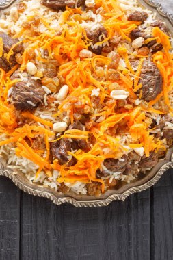 Kabuli Pulao Afgan pilavı ve kuzu pilavı ahşap masadaki tabağa yakın plan. Yukarıdan dikey üst görünüm