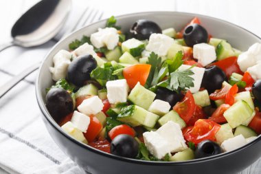Türk Çoban Salatası ahşap masadaki kaseye yakın duran dolmalık biber, salatalık ve peynir gibi taze sebzelerle yapılan lezzetli bir yemektir. Yatay