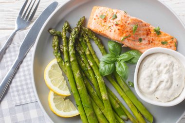 Tartar soslu kuşkonmaz ve limonlu somon filetosu masanın üstünde. Yukarıdan yatay üst vew