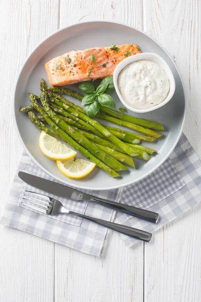 Tartar soslu kuşkonmaz ve limonlu somon filetosu masada servis edilir. Yukarıdan dikey vew