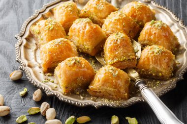 Tatlı şam fıstıklı baklava. Masanın üzerinde bal var. Yatay