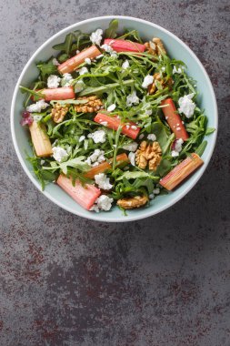 Fırında ravent, roka, keçi peyniri ve bal soslu cevizli salata masanın üstünde. Yukarıdan dikey üst görünüm