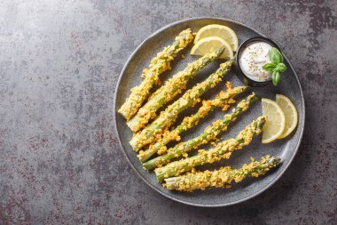 Ev yapımı Panko Fırınlanmış Kuşkonmaz. Masada çeşitli baharatlar var. Yukarıdan yatay üst görünüm