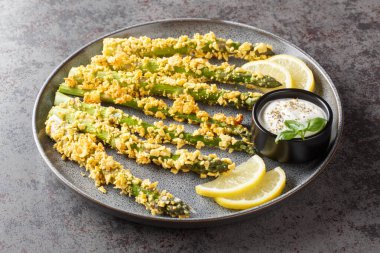 Ev yapımı Panko Fırınlanmış Kuşkonmaz. Masada çeşitli baharatlar var. Yatay