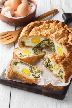 Torta Pasqualina geleneksel İtalyan baharatlı turtası ıspanak, pazı, ricotta ve yumurtanın tamamı masanın üzerinde. Dikey