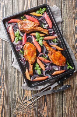 Pişmiş ballı domuz pirzolası, kırmızı soğan ve fırında pişirme tepsisiyle yakın plan. Yukarıdan dikey üst görünüm