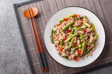 Asya usulü kızarmış domuz kıyması, kuşkonmaz, sarımsak, acı biber, soya sosu ve masada susam sosu. Yukarıdan yatay üst görünüm