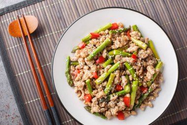 Kuşkonmaz, sarımsak, kırmızı biber ve masa üstünde susam soslu leziz kızarmış domuz eti. Yukarıdan yatay üst görünüm