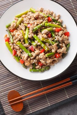 Baharatlı kızarmış domuz eti, kuşkonmaz, sarımsak, biber, soya sosu ve masada susam sosu. Yukarıdan dikey üst görünüm