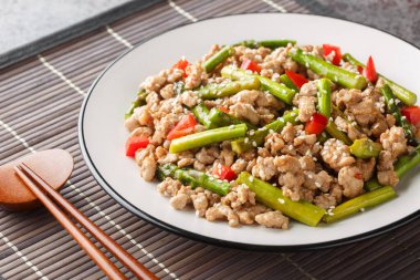 Kuşkonmaz, sarımsak, kırmızı biber ve zencefilli domuz kızartması masanın üstünde. Yatay