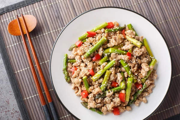 Kuşkonmaz, sarımsak, kırmızı biber ve masa üstünde susam soslu leziz kızarmış domuz eti. Yukarıdan yatay üst görünüm