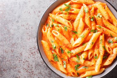 Ezilmiş domateslerden yapılmış pembe makarna sosu, İtalyan peyniri ve masanın üzerindeki ağır krem kaplama. Yukarıdan yatay üst görünüm