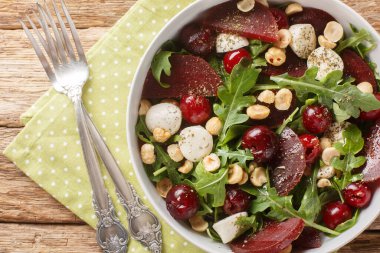 Vejetaryen roka salatası, pancar, olgun kiraz, peynir ve fındıklar masanın üstünde. Yukarıdan yatay üst görünüm