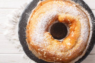 Ciambellone masanın üzerinde duran klasik bir İtalyan zeytinyağlı keki. Yukarıdan yatay üst görünüm